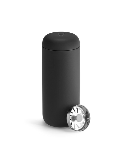 A matte black Fellow Carter Move Mug paired with a metal strainer lid.